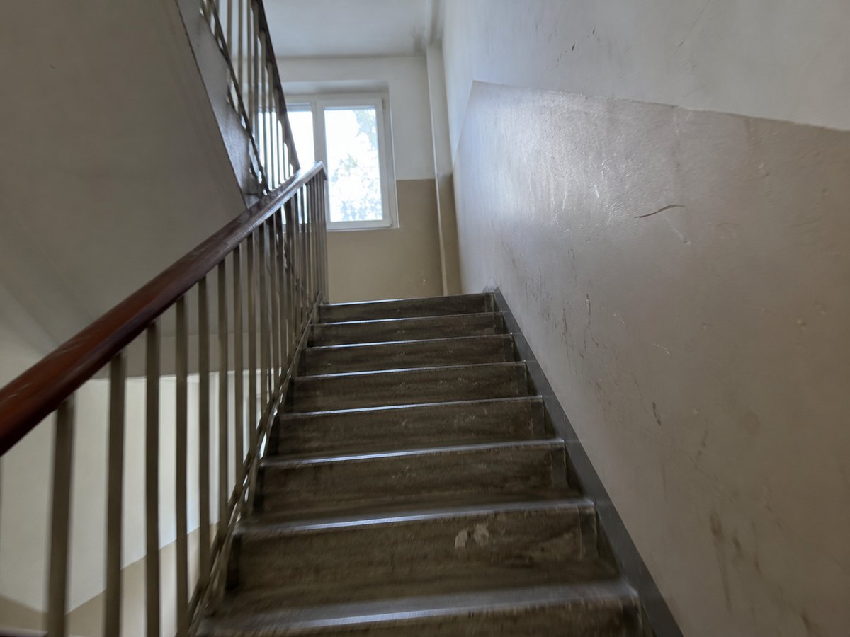 Worn staircase with a handrail in an apartment building